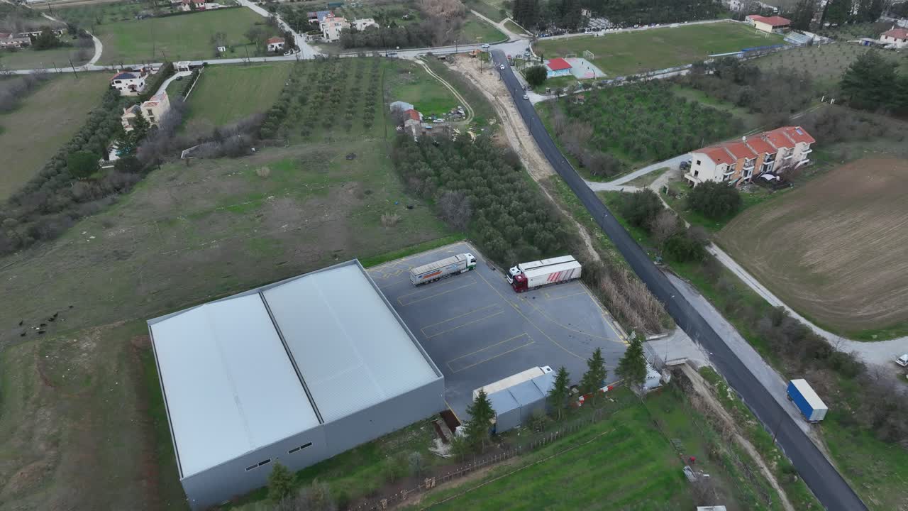 A water and soda production warehouse in a rural landscape, aerial view