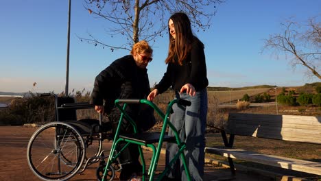 granddaugther helping grandmother to change the wheelchair for the walker