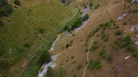 Birdseye-aerial-view-looking-down-hiking-meadow-valley-in-Peak-district-rural-countryside