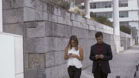 young people using cell phones in city