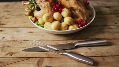 Video-of-tray-with-roasted-turkey,-potatoes-and-cutlery-on-wooden-surface