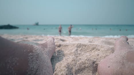 fellow feet in beach sand against blue ocean waves in summer