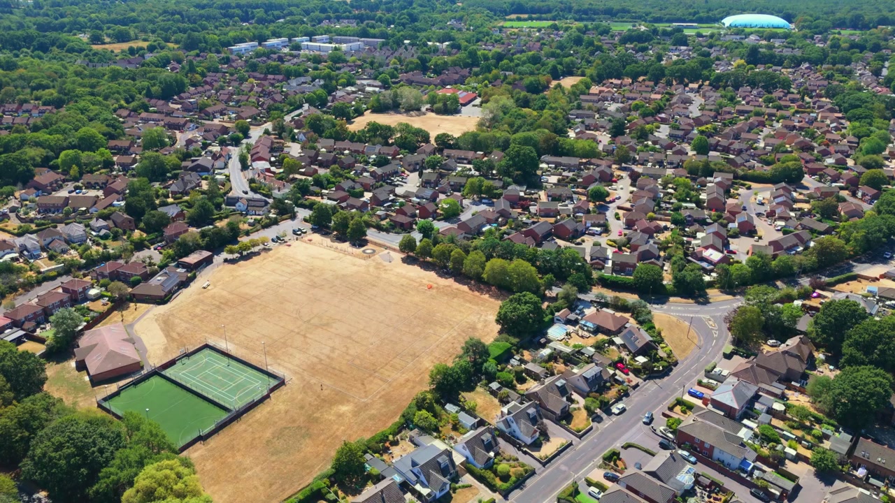 Marchwood è un villaggio dell'Hampshire sul Southampton Water, vicino alla New Forest, che presenta complessi residenziali, cantieri navali locali e un importante porto militare in una soleggiata giornata estiva con erba secca