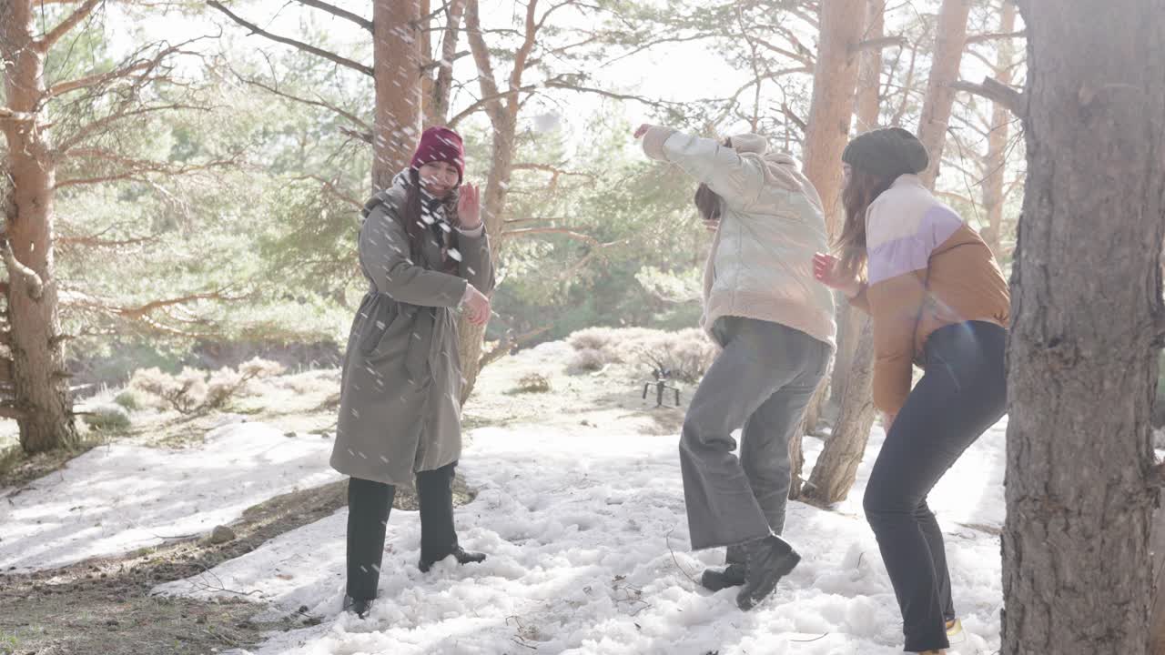 Women Enjoying a Snowball Fight in the Forest
