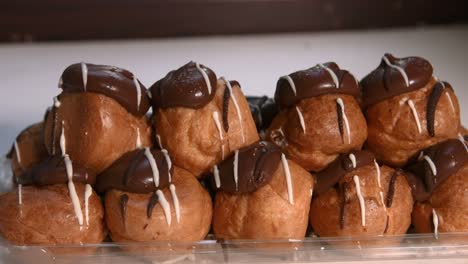 small stack of profiteroles choux pastry with whipped cream filling and chocolate topping