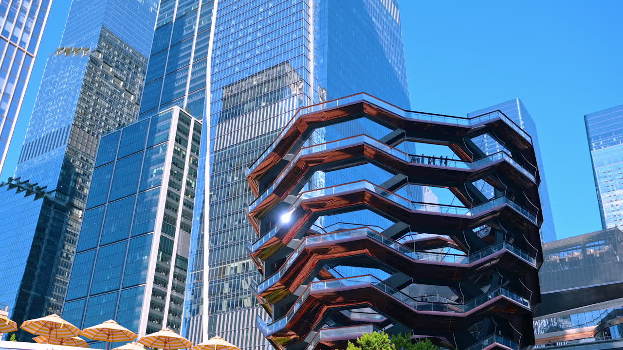 New York, USA, 4 August 2025: Modern glass towers and the Vessel structure in Hudson Yards, New York. A view of modern skyscrapers alongside the Vessel landmark