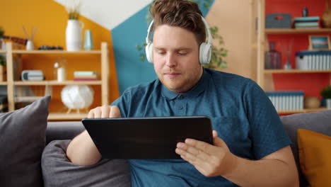 Man using tablet with headphones