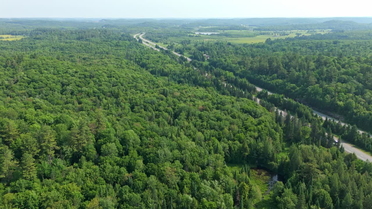 Drone flyover of Highway 11 in Muskoka with surrounding green forest