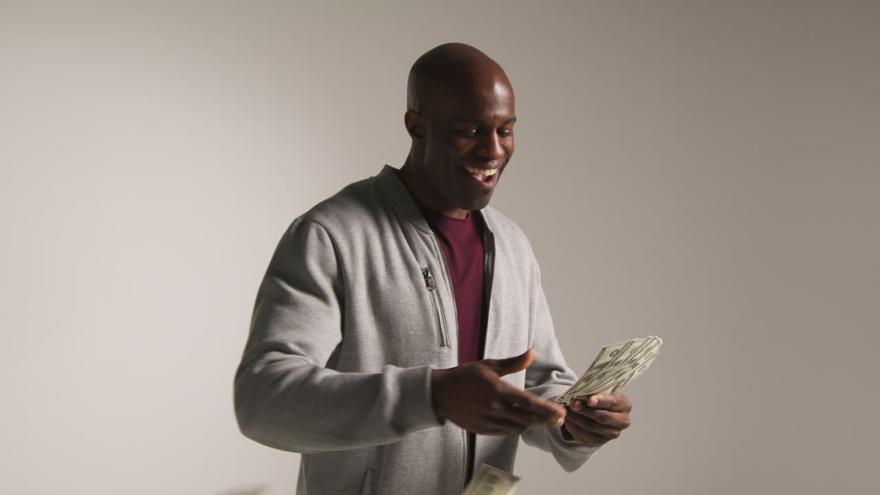 Studio Shot Of Excited Mature Man Celebrating Winning Cash Prize Throwing Handful Of 100 Dollar Bills In The Air 1