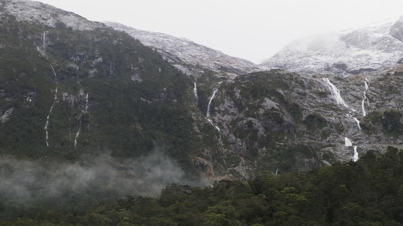 Majestic waterfalls cascading down the fjord mountains in New Zealand's Milford Sound, fed by snowpack