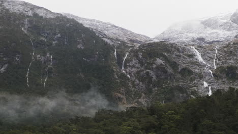 Majestic-waterfalls-cascading-down-the-fjord-mountains-in-New-Zealand's-Milford-Sound,-fed-by-snowpack