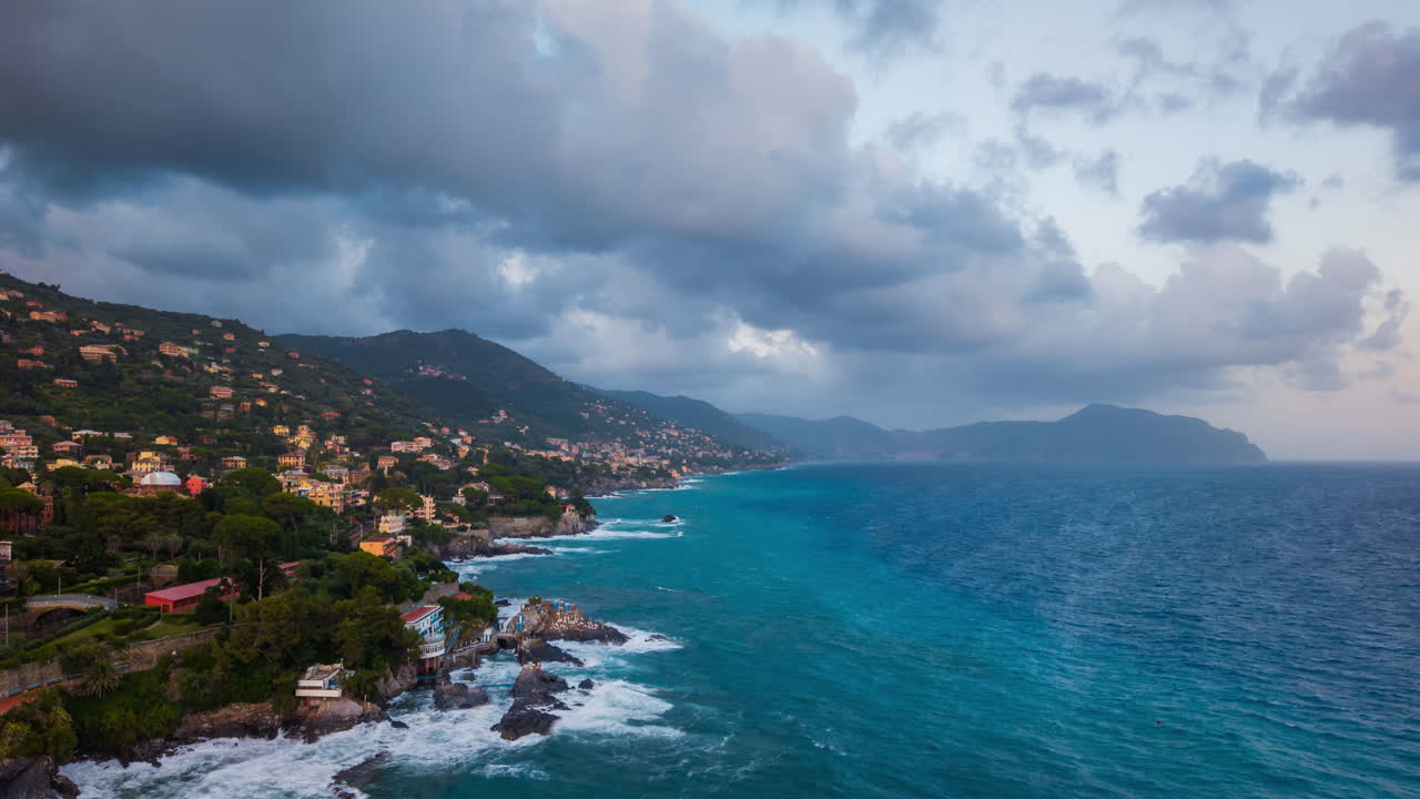 Timelapse di nuvole che si muovono sul mare al tramonto vicino alla costa italiana, con onde blu dell'oceano, colline panoramiche, cielo e una tranquilla città costiera in Italia