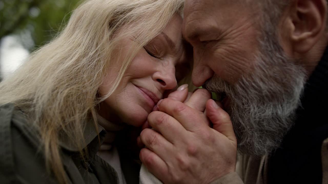 외에서 손을 잡고 있는 노인 부부