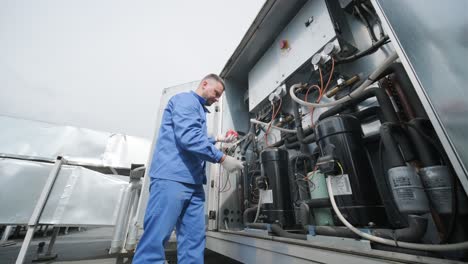 el técnico repara los sensores electrónicos de temperatura con un soldador electrónico