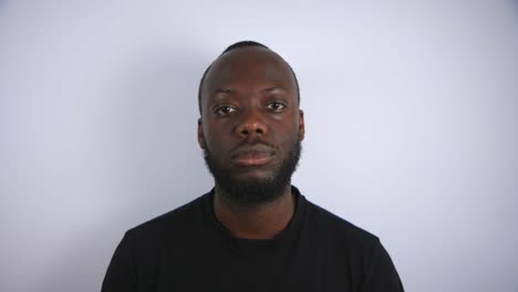 black male looking up to camera and staring with a blank face with white background