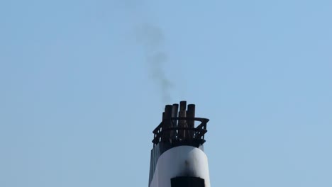 chimney releasing smoke against a clear sky