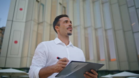 confident man studying documents at street on go closeup. businessman crossing