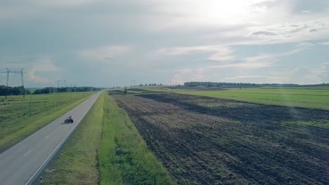 Paar-Aus-Der-Vogelperspektive-Auf-Einem-Motorrad,-Das-Von-Der-Sommersonne-Beleuchtet-Wird