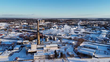 Smoky-chimneys-seen-from-above,-snow-covered-buildings,-Silute,-Lithuania