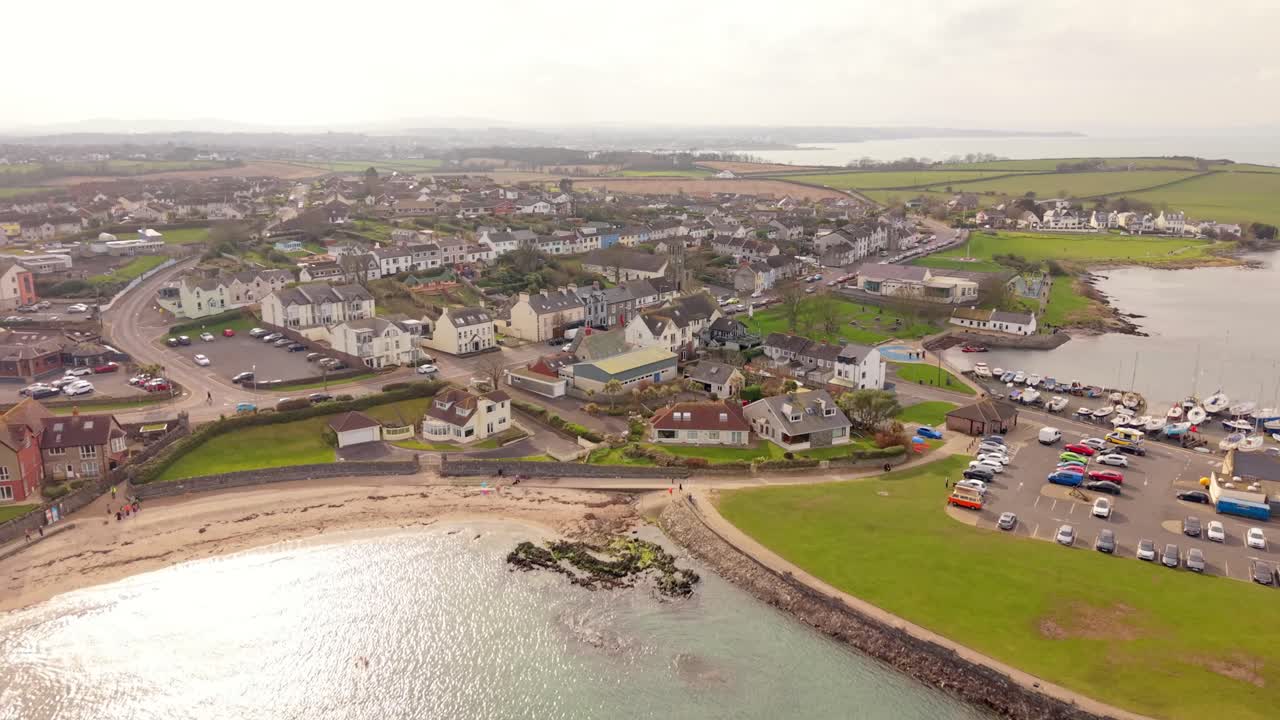 Ampio video aereo in avanzamento a 4K 60FPS del villaggio e della spiaggia di Groomsport nella contea di Down, Irlanda del Nord. Prodotto con colorimetria Rec709.