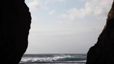 avión distante pasando isla remota aislada en bali indonesia