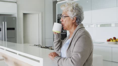 Afroamerikanische-Seniorin-Trinkt-Kaffee-In-Der-Küche-Zu-Hause