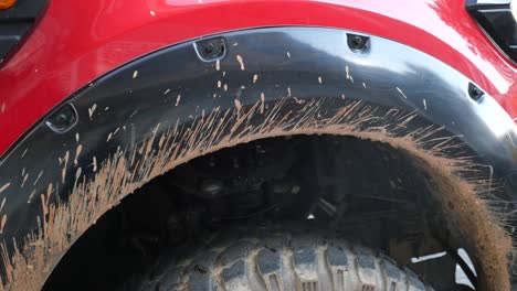 muddy red off-road car fender