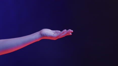 hand of asian woman, touching virtual screen on blue background, copy space, slow motion