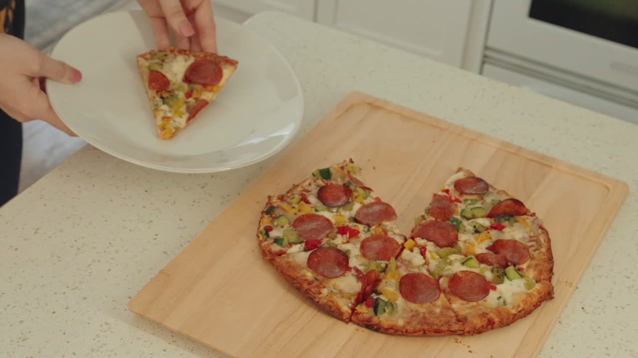 Pizza slice served on a plate with colorful vegetables and pepperoni on the pizza