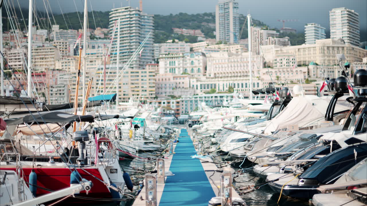 View of boats docked in the Monaco Marina with the skyline of the city on the background