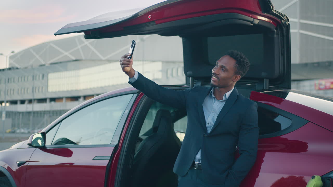 hombre tomando una selfie frente a un coche con techo abierto