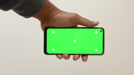 persona con un teléfono inteligente de pantalla verde