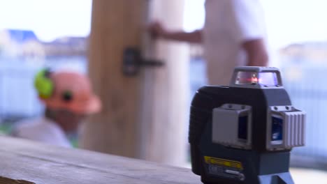 construction workers using laser level on log cabin