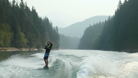 front view of caucasian young man doing tricks on wakeboard in the city river 4k