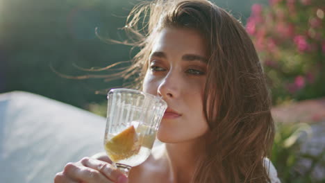 drinking woman enjoying water with fruits at open air sunshine balcony closeup