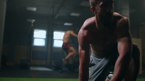 a tired man gets up from the floor after training and continues to move forward despite fatigue. overcome difficulties and achieve your goals