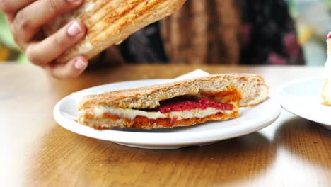 person eating a grilled sandwich