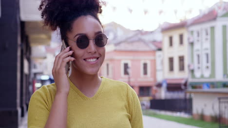 mujer en el teléfono sonriendo en la ciudad elegante
