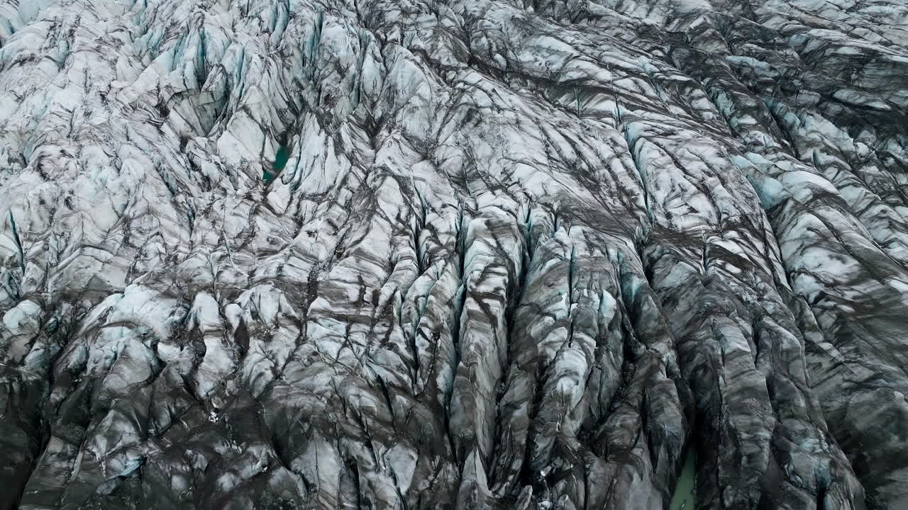 Ice terraces of glacier tongue, rough surface with crack pattern, aerial view