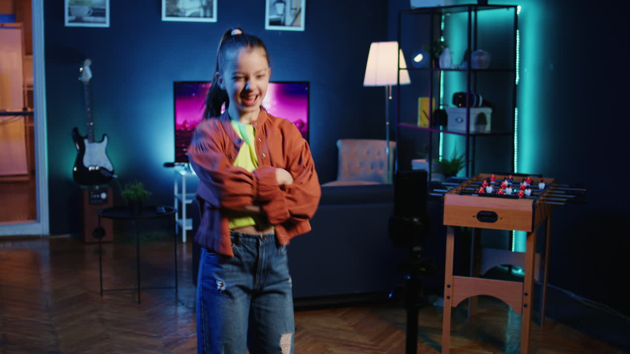 chico talentoso usando un teléfono inteligente en un estabilizador de trípode para filmar un tutorial de baile