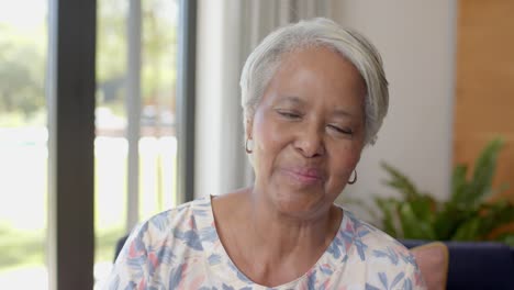 Portrait-of-happy-senior-biracial-woman-making-video-call-at-home,-unaltered,-in-slow-motion