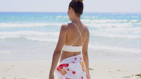 Playful-young-woman-dancing-on-the-beach