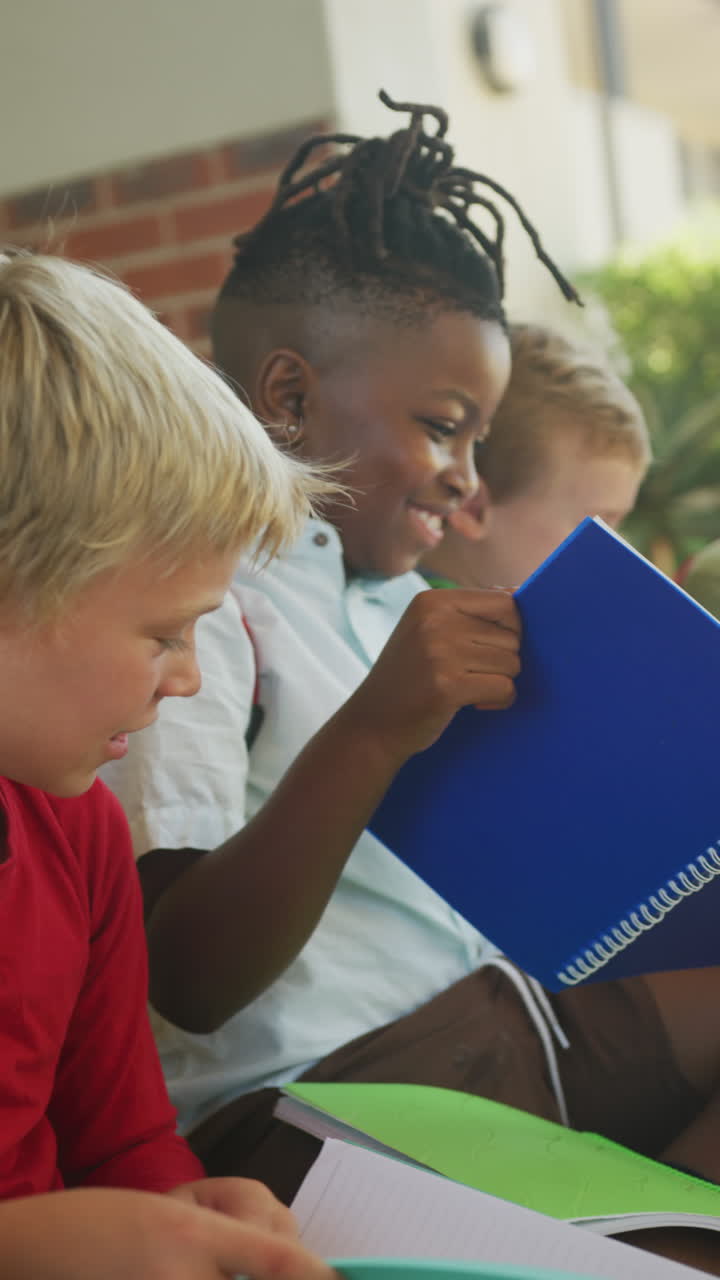 video vertical de escolares felices y diversos leyendo en la escuela