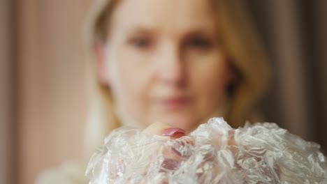 a woman pops bubble wrap 2