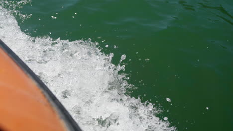 salpicaduras de agua mientras una lancha motora acelera en el mar azul tranquilo en un día de verano - toma cenital