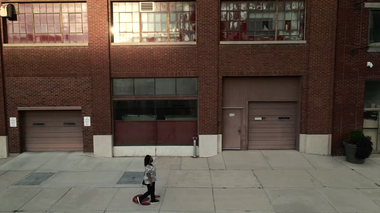 Minority woman walking alone wearing a mask.