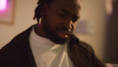 close up of confused man waking up on sofa after drinking alcohol at house party suffering with hangover