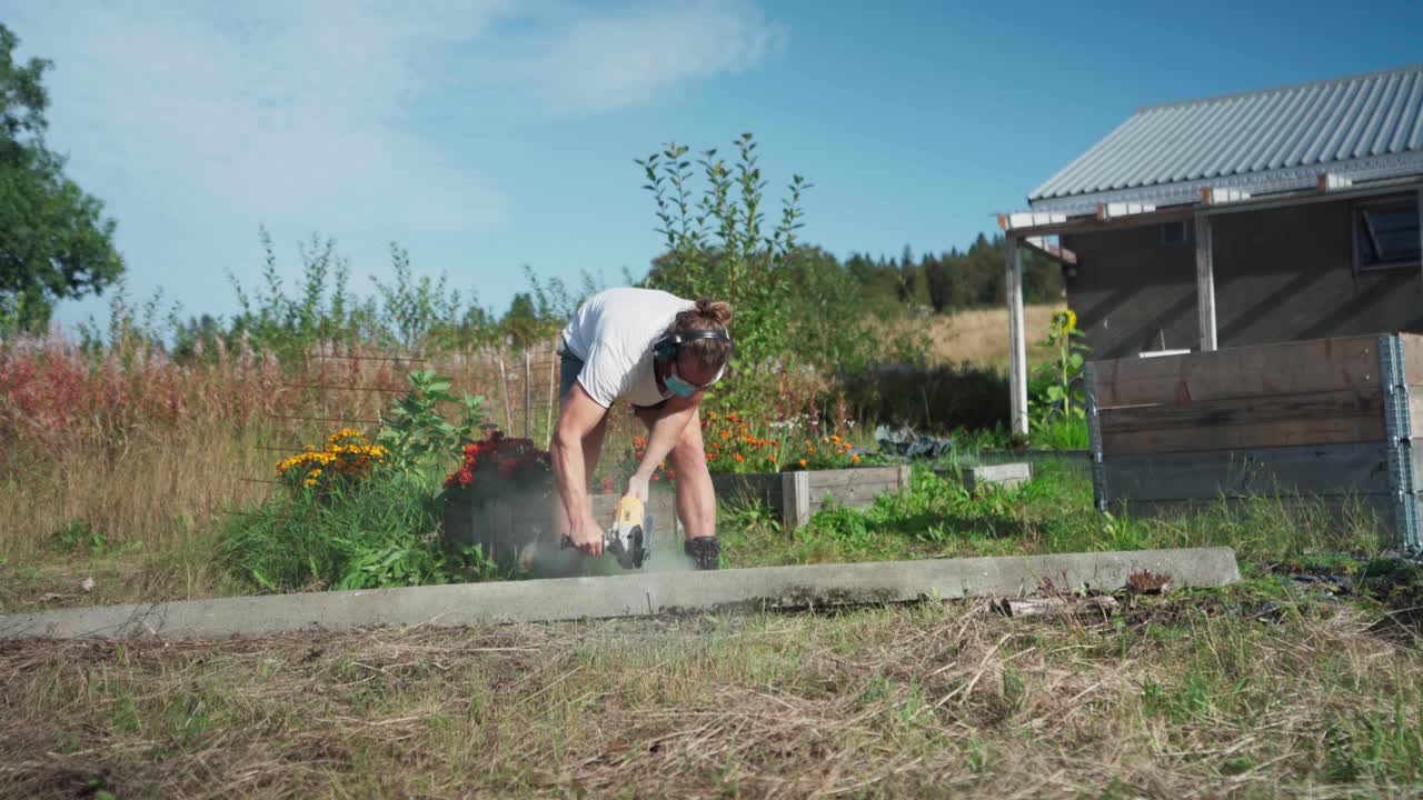 un hombre está usando una herramienta para cortar la madera destinada a la construcción de un invernadero en indre fosen, condado de trondelag, noruega - toma estática