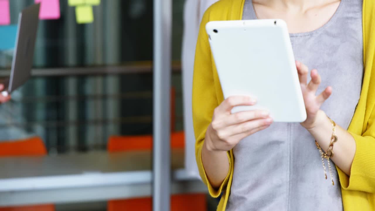 Woman tapping white tablet and causing animated overlay sweeping across glass for business planning