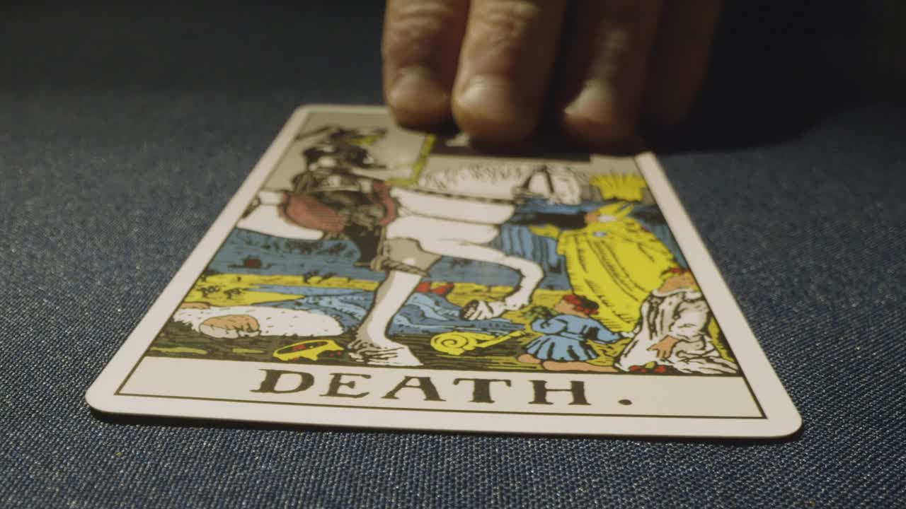 타로 카드 판독 을 하는 사람 이 테이블 위 에 죽음 카드 를 놓고 있는 근접 촬영